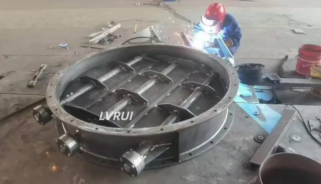 Technician welding an industrial louver damper in cement plant workshop